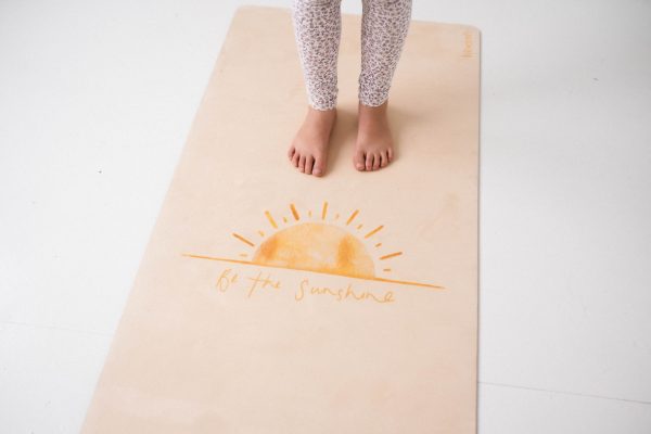 Be the Sunshine pilates mat with feet standing on it