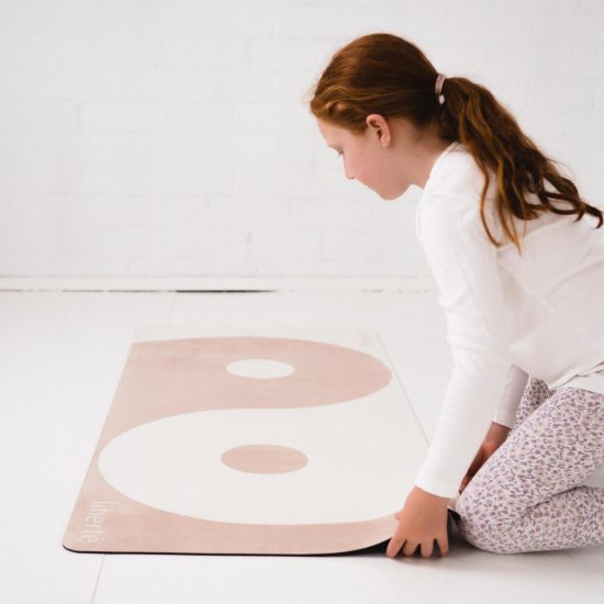 child setting up pilates mat
