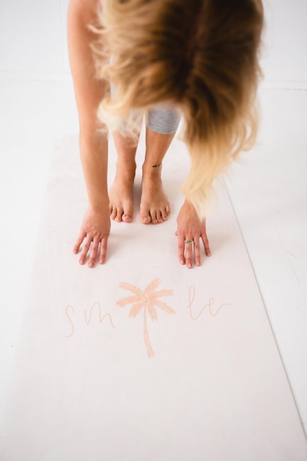 lady bending down on smile pilates mat