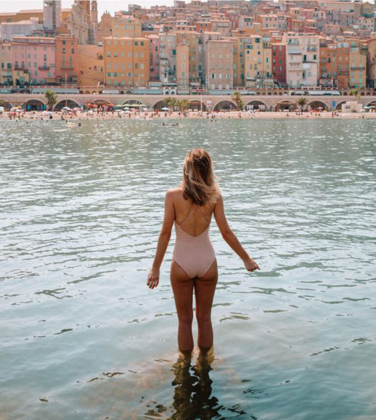 Pilates retreat to France with woman standing in water facing the city
